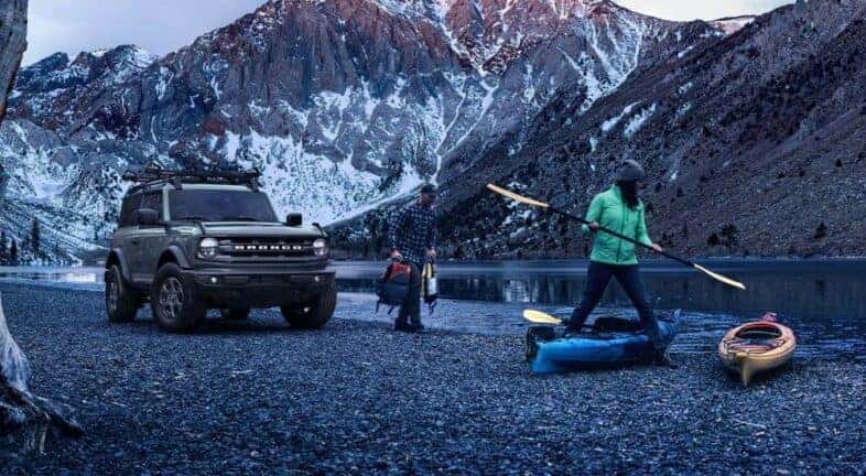 A grey 2024 Ford Bronco Big Bend is shown near a river and people kayaking.