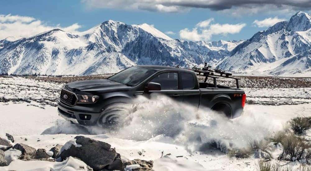 A black 2023 Ford Ranger XLT FX4 is shown kicking up snow.