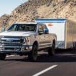 A white 2024 Ford F-350 is shown towing a trailer.