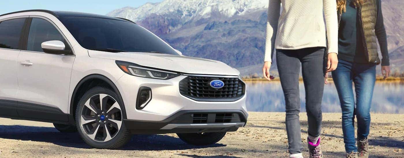 A white 2023 Ford Escape Platinum is shown parked near a lake.
