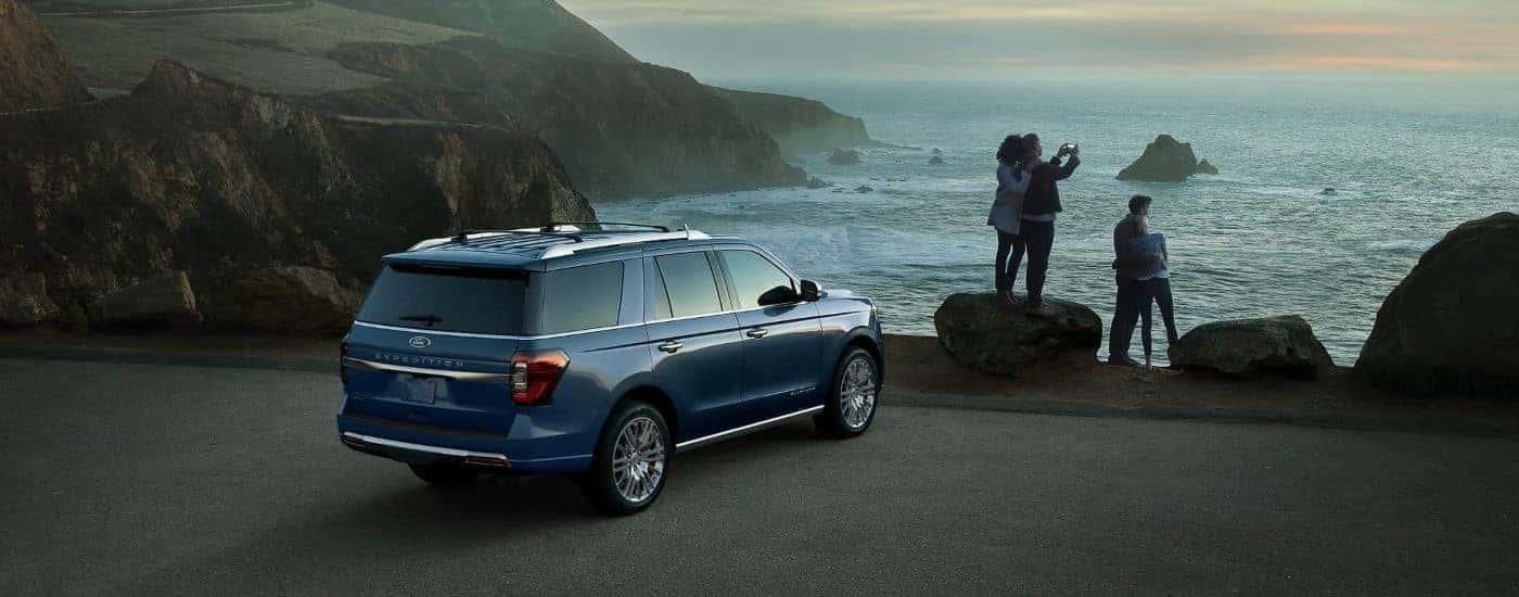 A blue 2023 Ford Expedition is shown parked near the ocean.