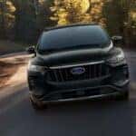 A black 2024 Ford Escape is shown from a front angle while driving from a Ford EV dealership near Catskill.