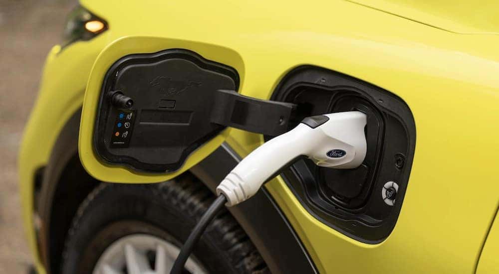 A close-up of a yellow 2024 Ford Mustang Mach-E charging is shown.