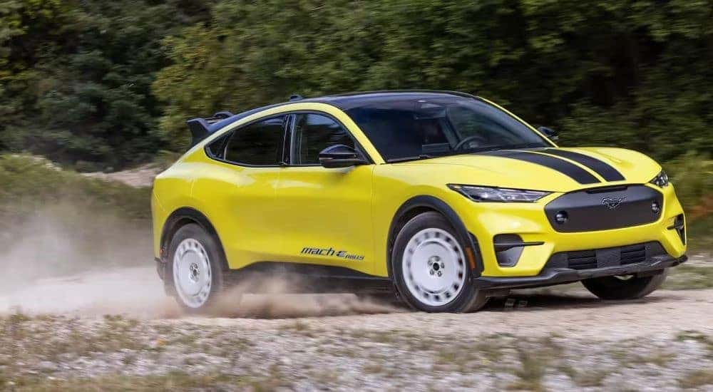 A yellow 2024 Ford Mustang Mach-E is shown driving off-road after a 2024 Ford Mustang Mach-E vs 2024 Nissan ARIYA comparison.