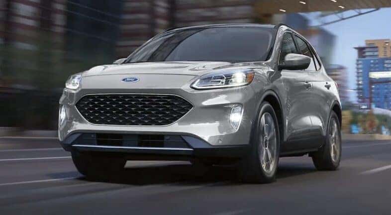 A grey 2021 Ford Escape is shown driving from a dealer with a used Ford Escape for sale is shown.