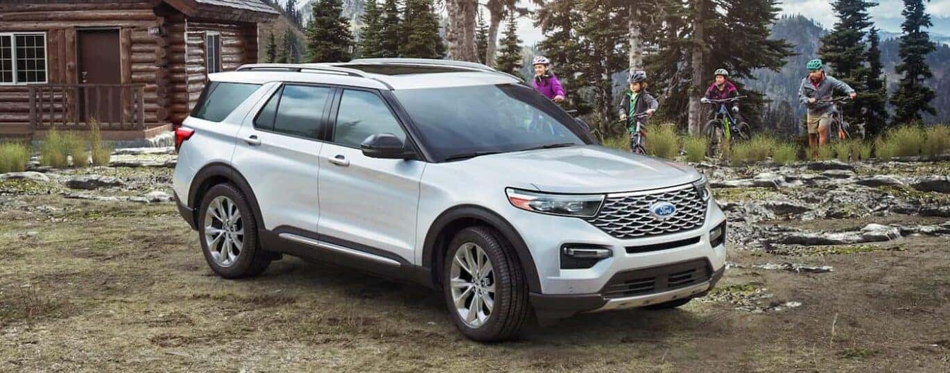 A white 2024 Ford Explorer is shown parked off-road.