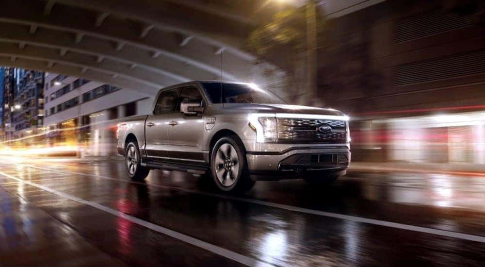 A silver 2023 Ford F-150 Lightning is shown driving in a tunnel.