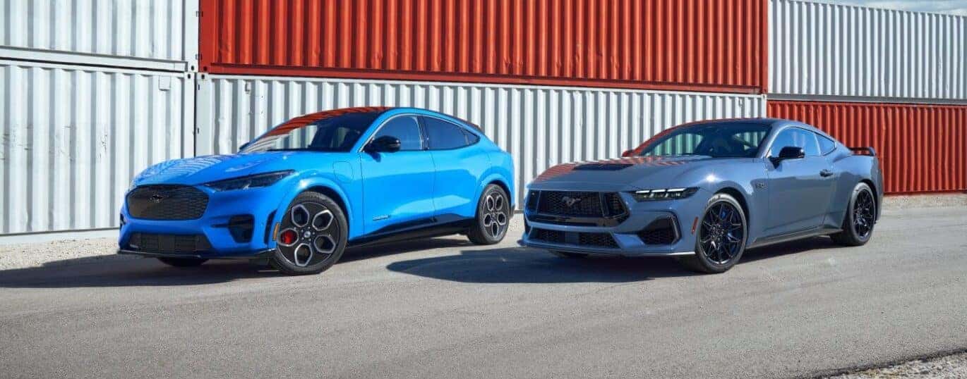 A pair of blue 2024 Ford Mustang Mach-E's are shown parked near shipping containers after a 2024 Ford Mustang Mach-E vs 2024 Volkswagen ID.4.