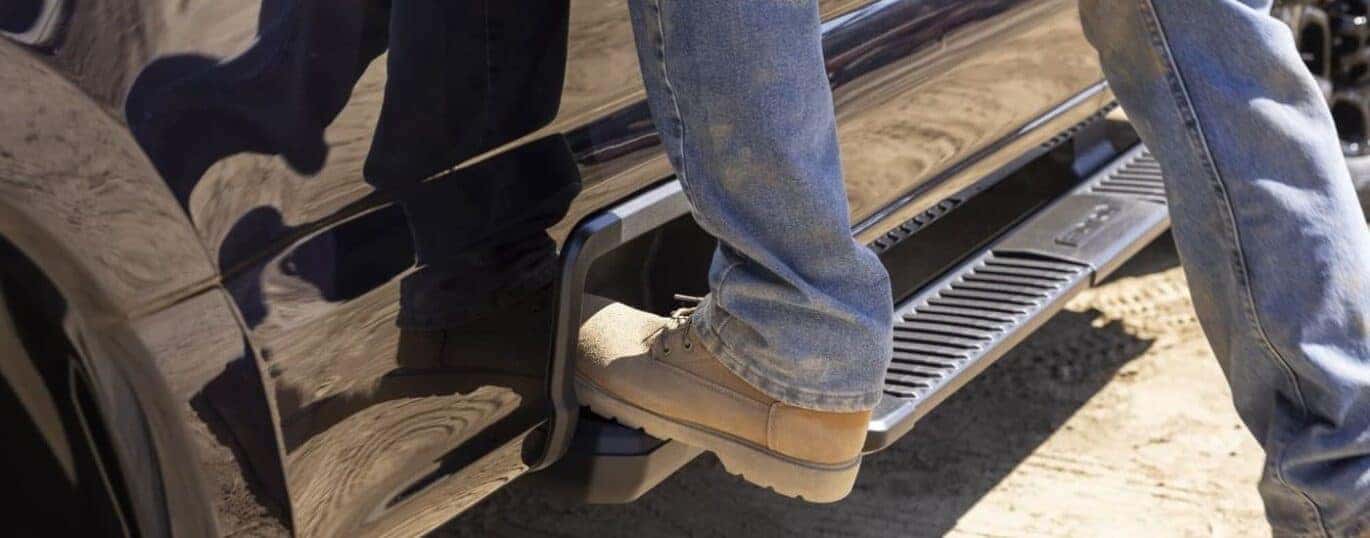 A person is shown stepping on the running board of a black 2024 Ford F-250 XL STX