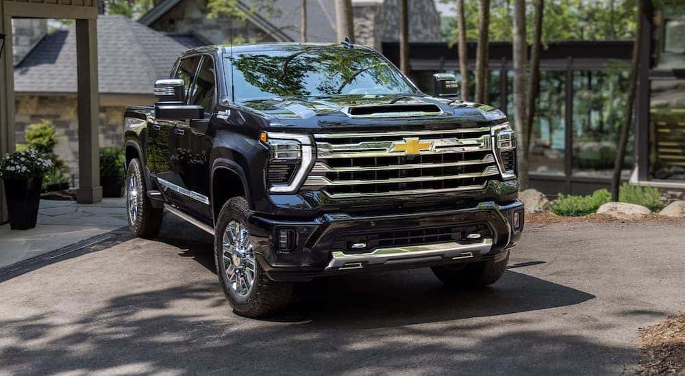 A black 2024 Chevy Silverado HD parked in a driveway.