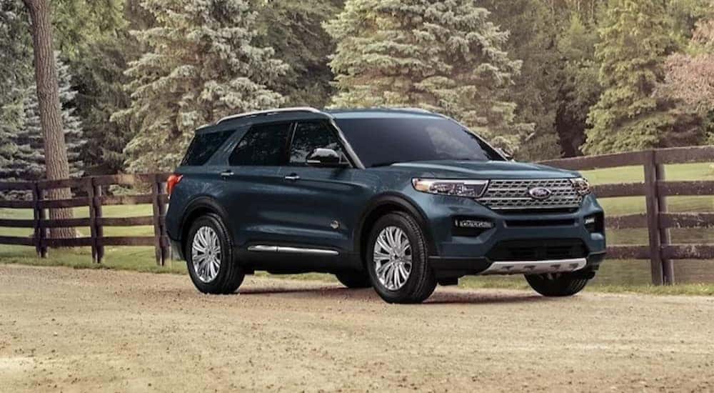A green 2024 Ford Explorer King Ranch is shown parked near a fence after a 2024 Ford Explorer vs 2024 Chevy Traverse comparison.