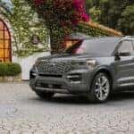 A grey 2024 Ford Explorer Platinum parked in a brick garden patio.