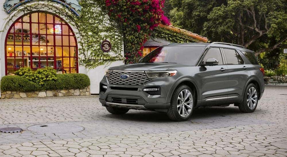 A grey 2024 Ford Explorer Platinum parked in a brick garden patio.