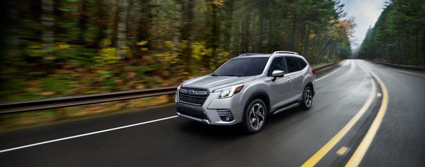 Silver 2023 Subaru Forester driving on a winding road