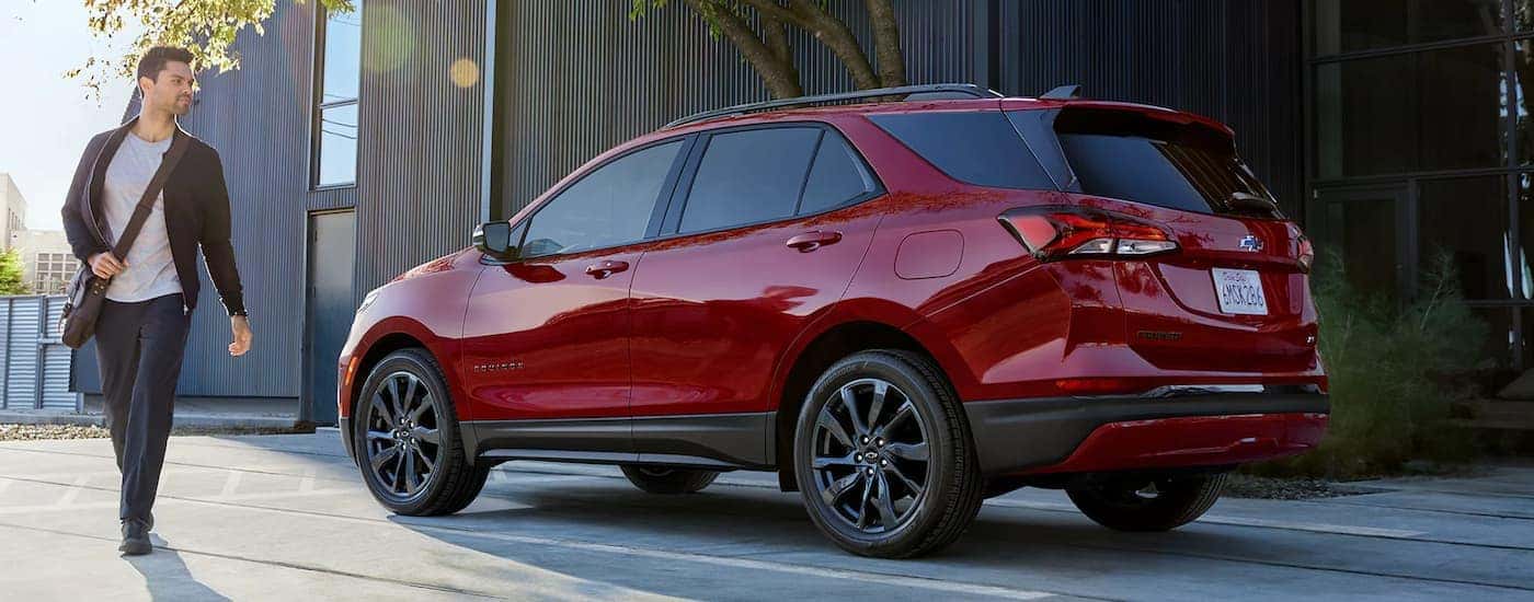 A red 2022 Chevy Equinox RS is parked in a city.