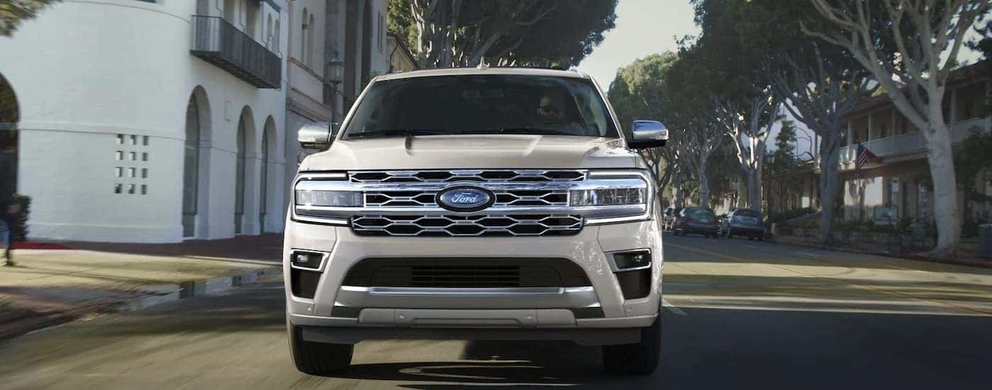 A front view of a white 2022 Ford Expedition Platinum driving on a city street.