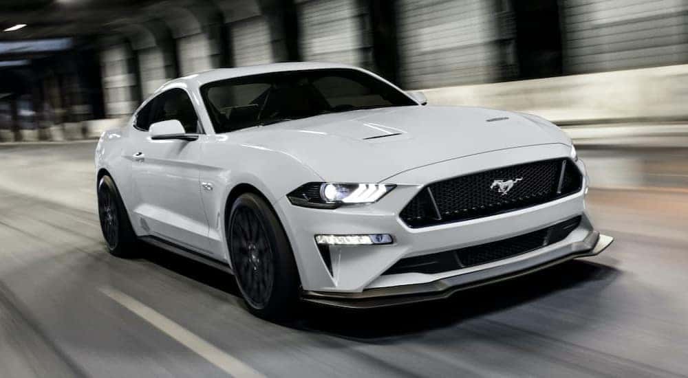 A white 2020 Ford Mustang GT is shown driving through a tunnel after visiting a dealer with used cars for sale near Schenectady.