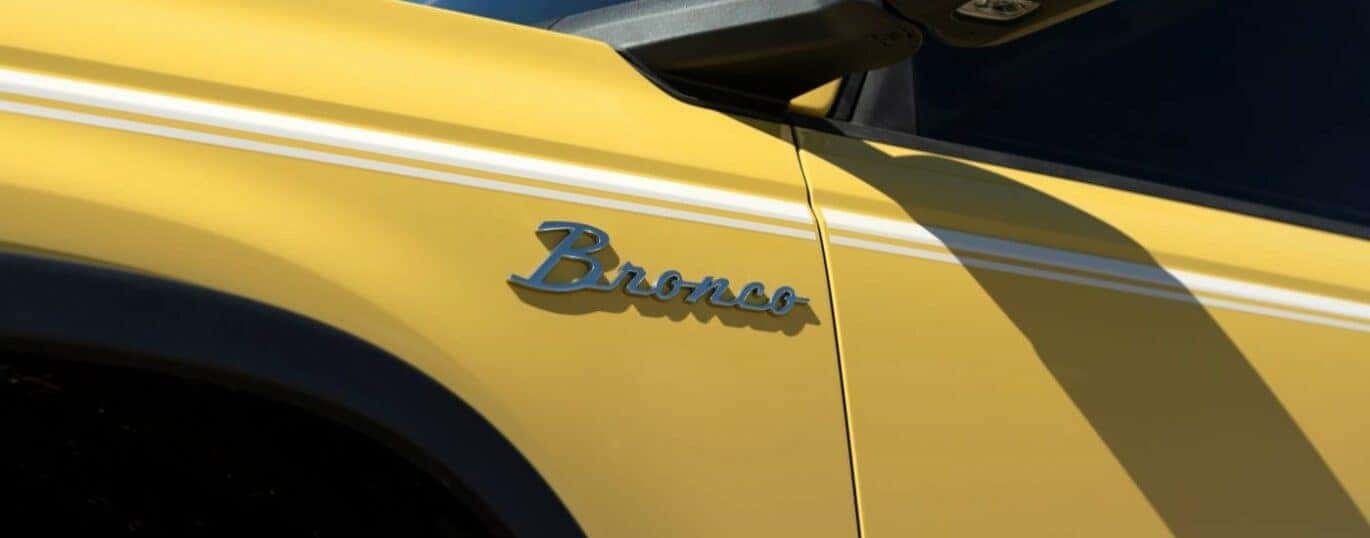 A close-up on the badge of a yellow 2024 Ford Bronco Heritage.