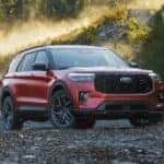 A red 2025 Ford Explorer is shown parked off-road.