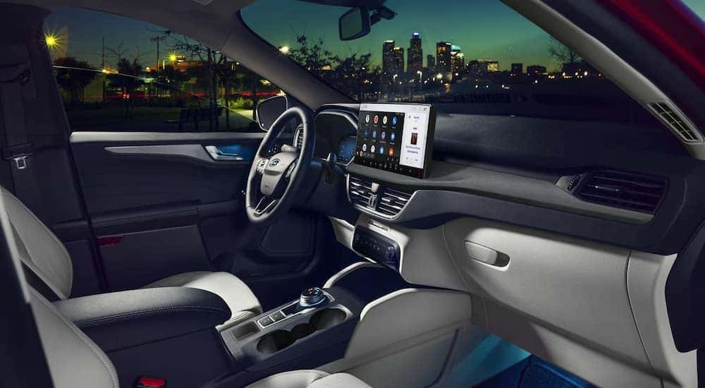 Blue ambient lighting and a large infotainment screen in the cabin of a 2024 Ford Escape.