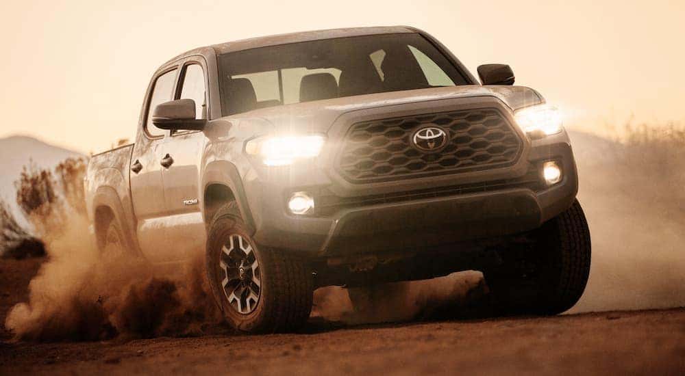 A grey 2020 Toyota Tacoma driving off-road in a desert.
