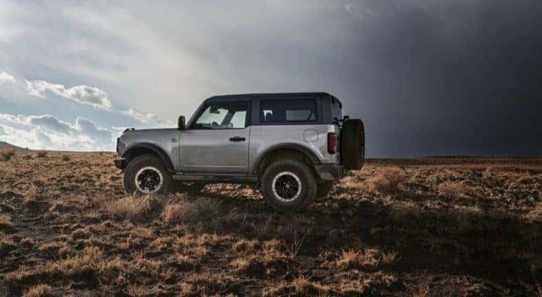 A silver 2023 Ford Bronco Outer Banks is shown parked off-road.