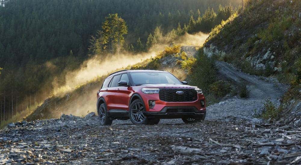 A red 2025 Ford Explorer parked off-road by a mountain.