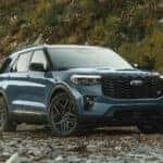 A blue 2025 Ford Explorer ST parked in a clearing.