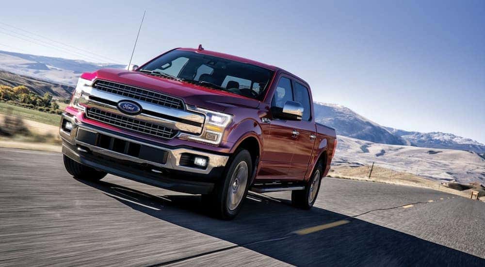 A red 2020 Ford F-150 is shown driving on a highway.