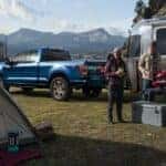 A blue 2022 Ford F-150 STX is shown parked on a campsite after viewing a used Ford F-150 for sale in Albany.