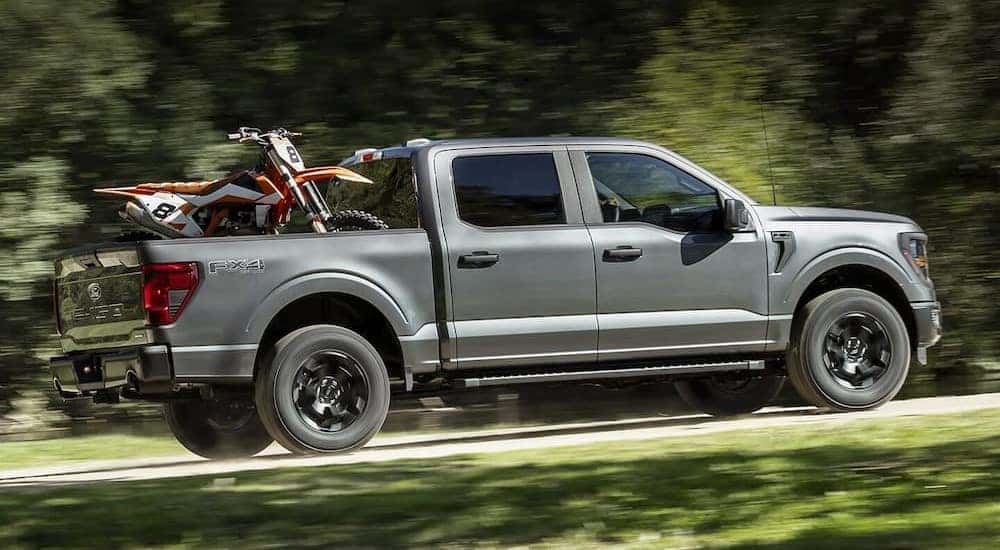 A gray 2024 Ford F-150 FX4 is shown driving uphill.