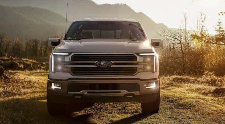 A white 2024 Ford F-150 for sale is shown parked on a sunny day.