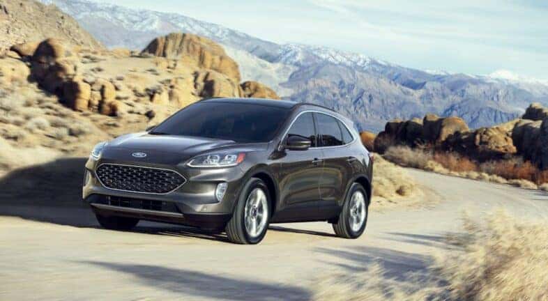 A black 2020 Ford Escape driving around a bend.