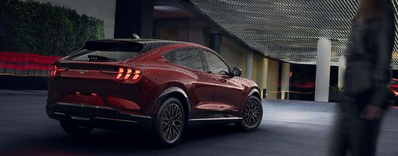 A red 2024 Ford Mustang Mach-E is shown parked under white lights.