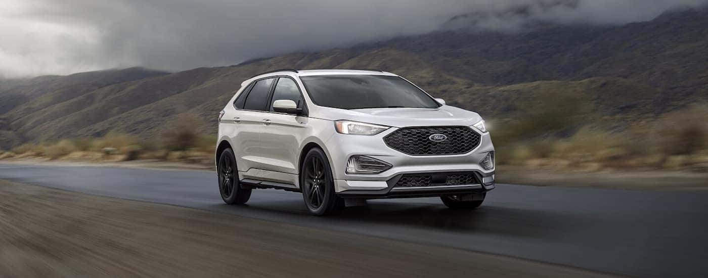 A white 2024 Ford Edge driving on the highway.