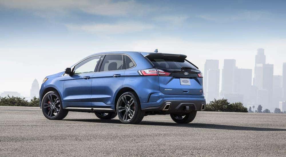 A blue 2024 Ford Edge ST is shown from the rear at an angle.