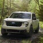 A white 2025 Ford Maverick XLT is shown driving off-road.