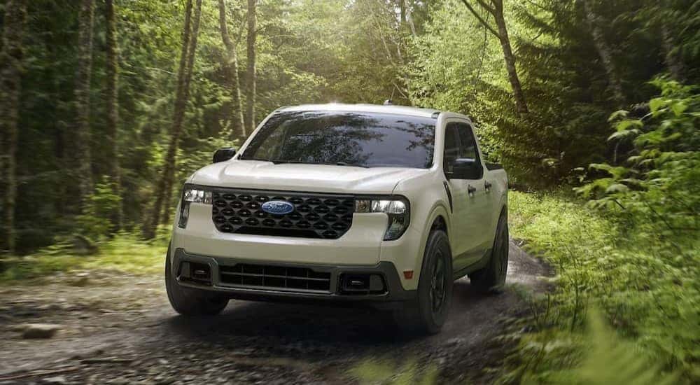 A white 2025 Ford Maverick XLT is shown driving off-road.