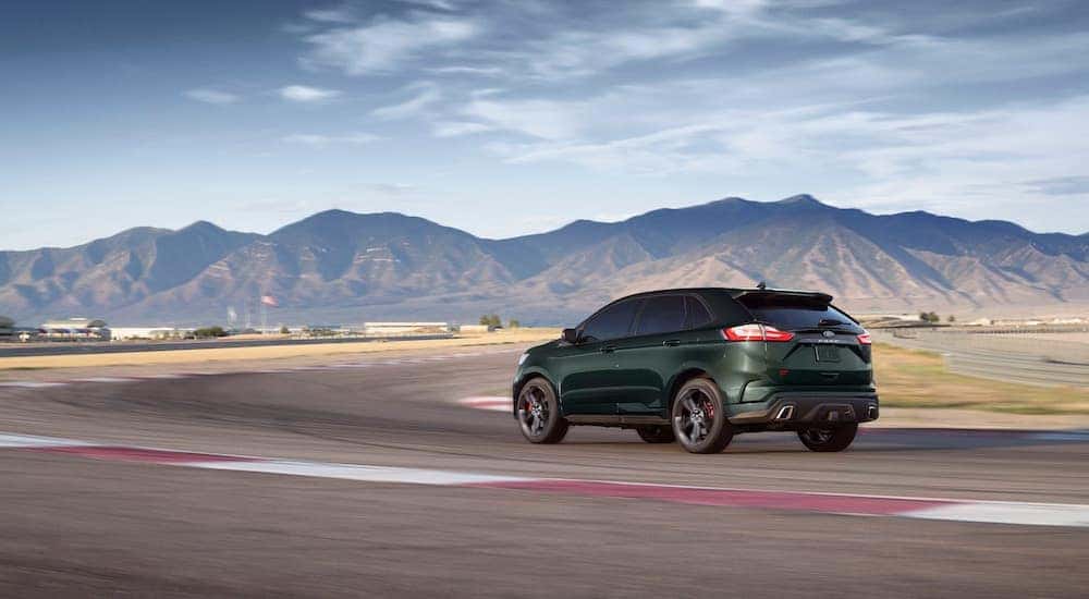 A green 2024 Ford Edge ST is shown from the rear at an angle.