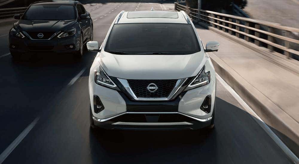Front angle view of a white 2023 Nissan Murano driving on a highway.