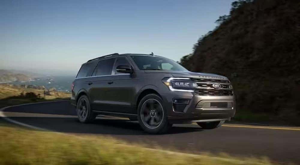 A gray 2024 Ford Expedition Platinum MAX is shown driving on a highway.