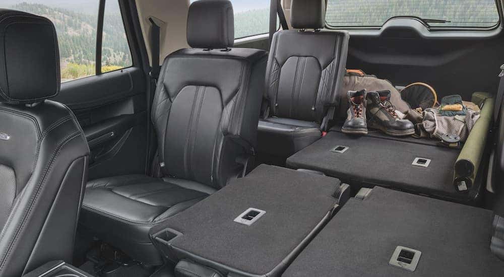 The black interior of a 2024 Ford Expedition is shown from the front seats looking back.