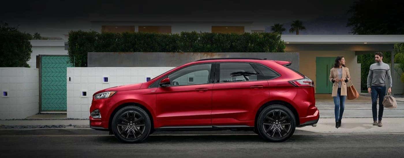 A red 2023 Ford Edge is shown parked near a city curb.
