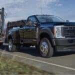 A black 2025 Ford F-450 is shown towing a trailer.