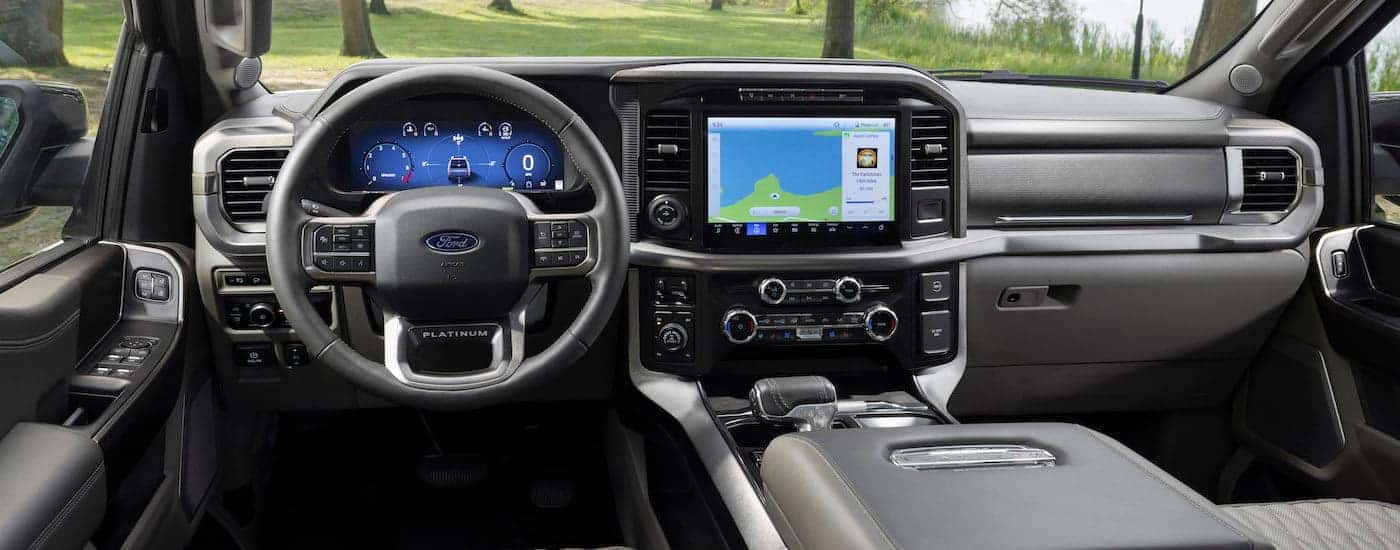 The grey interior of a 2024 Ford F-150 is shown from the driver's seat.
