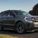 A grey 2022 Ford Expedition is driving on an open highway.