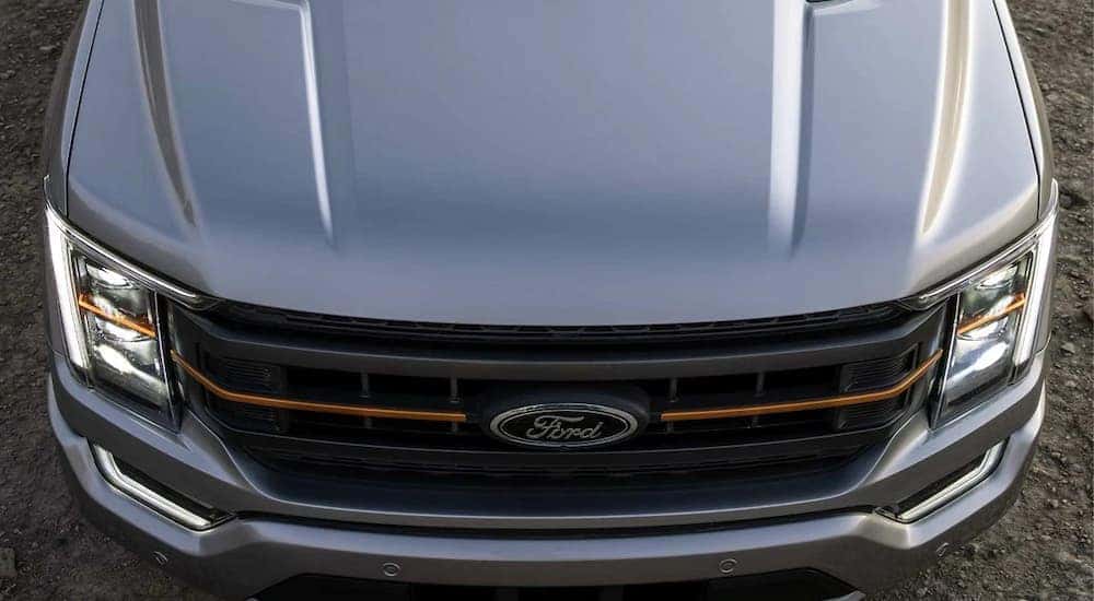 A close up of the front hood and grille on a grey 2022 Ford F-150 Tremor.