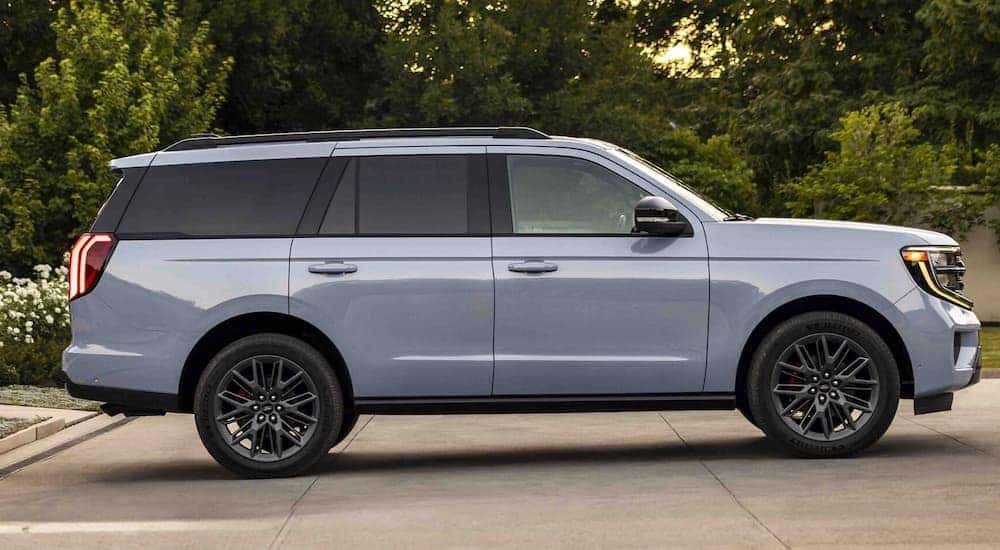 Side angle view of a blue 2025 Ford Expedition parked on a driveway.