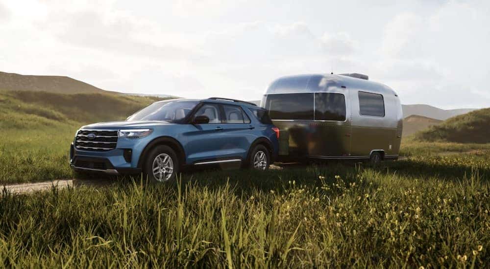 A blue 2025 Ford Explorer Active is shown parked while towing a trailer.