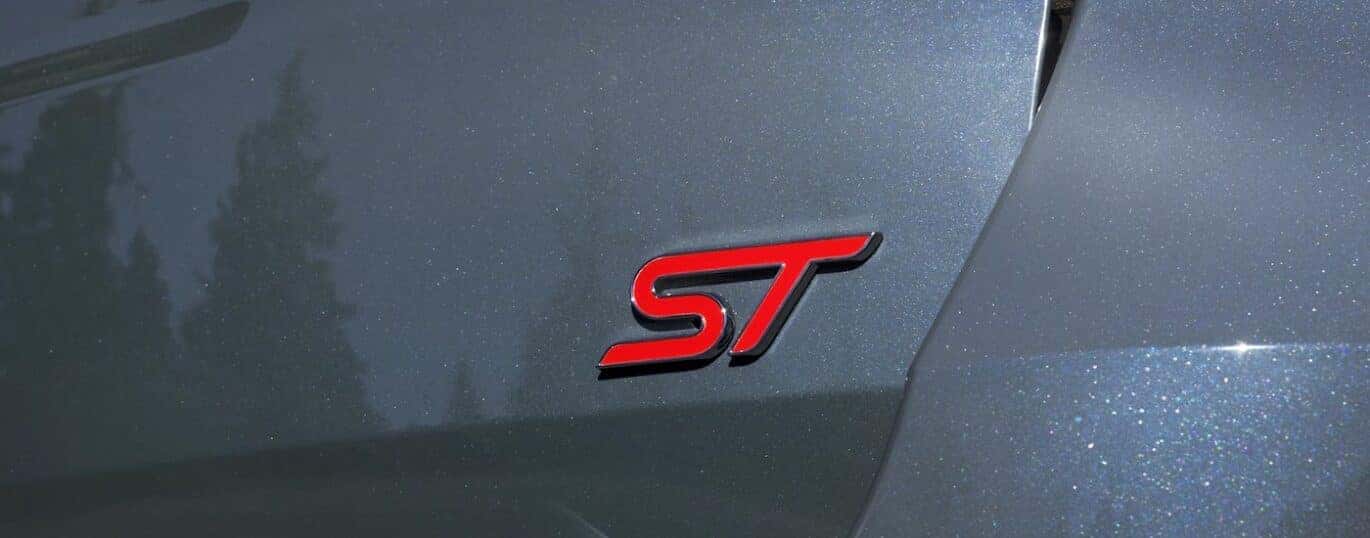 A close-up of the ST-Line badge is shown on a silver 2025 Ford Explorer ST-Line.